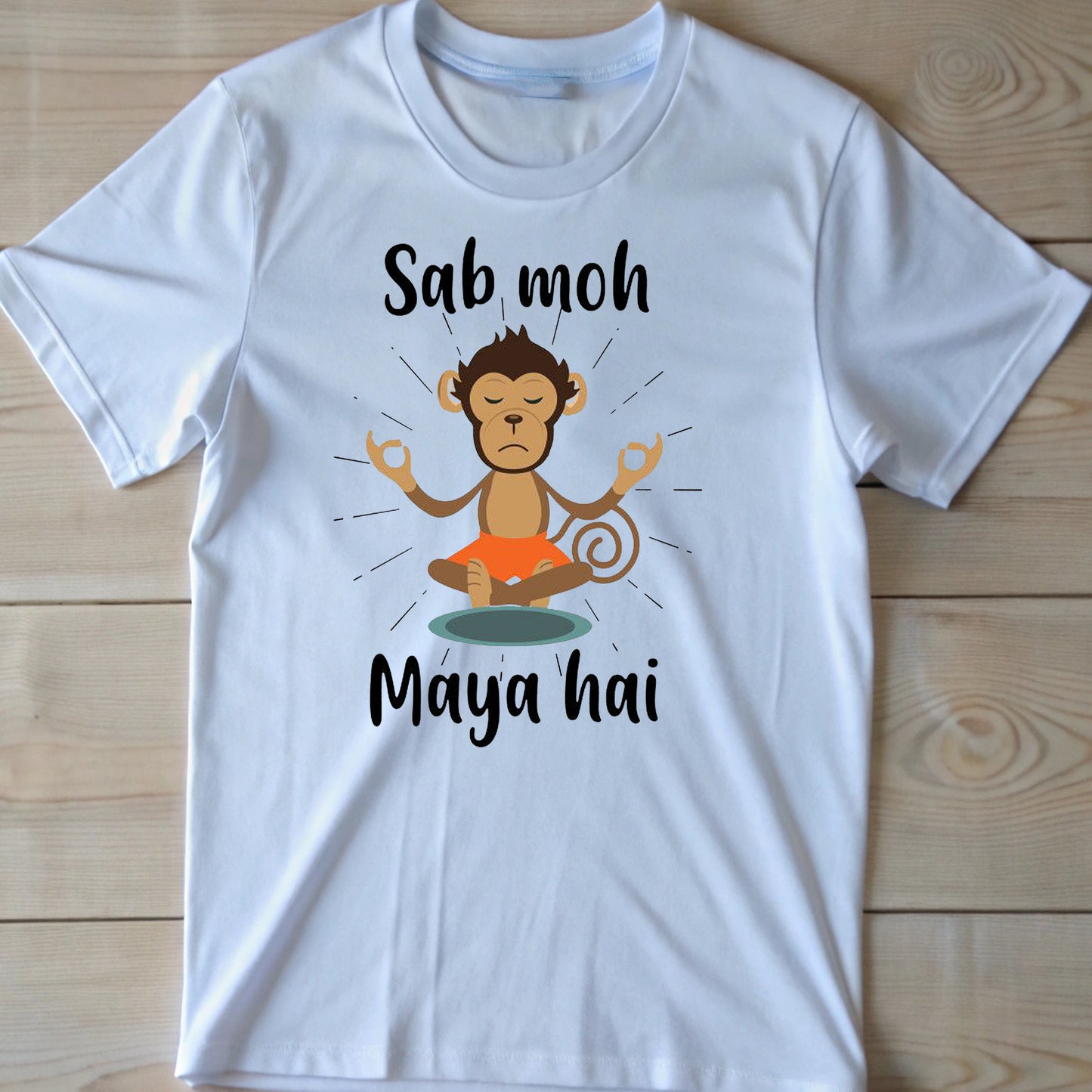 White t-shirt with black text "Sab moh" above a meditating cartoon monkey and "Maya hai" below it. The Hindi phrase "Sab moh maya hai" translates to "All worldly attachments are illusions".