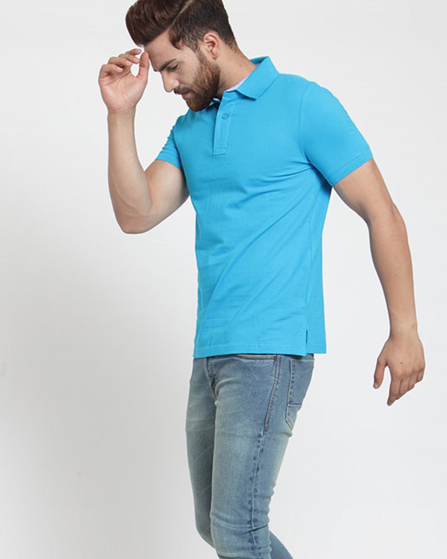 Left hand view of a man wearing a sky blue polo t-shirt