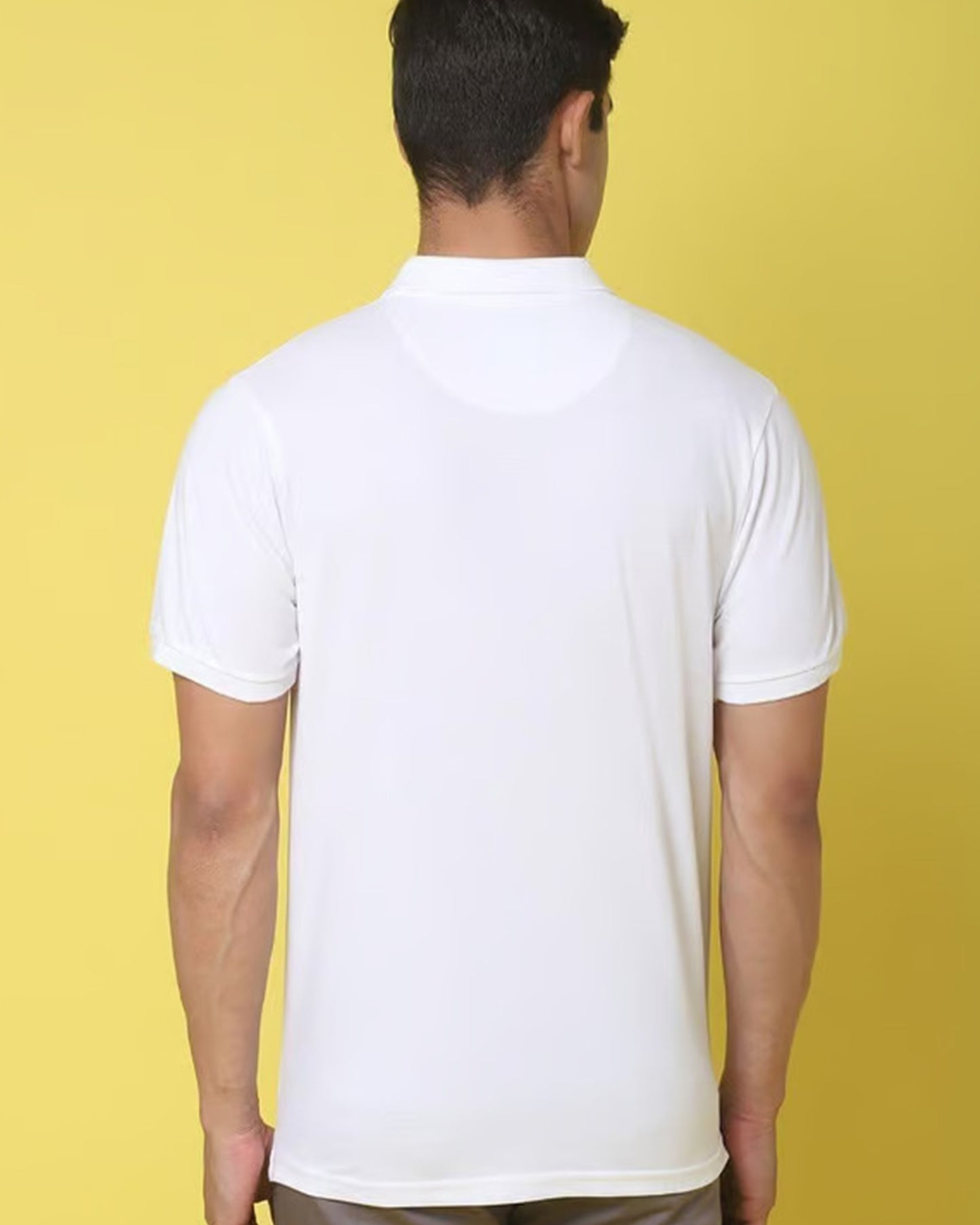 Back view of a men wearing a simple white short-sleeved polo t-shirt.