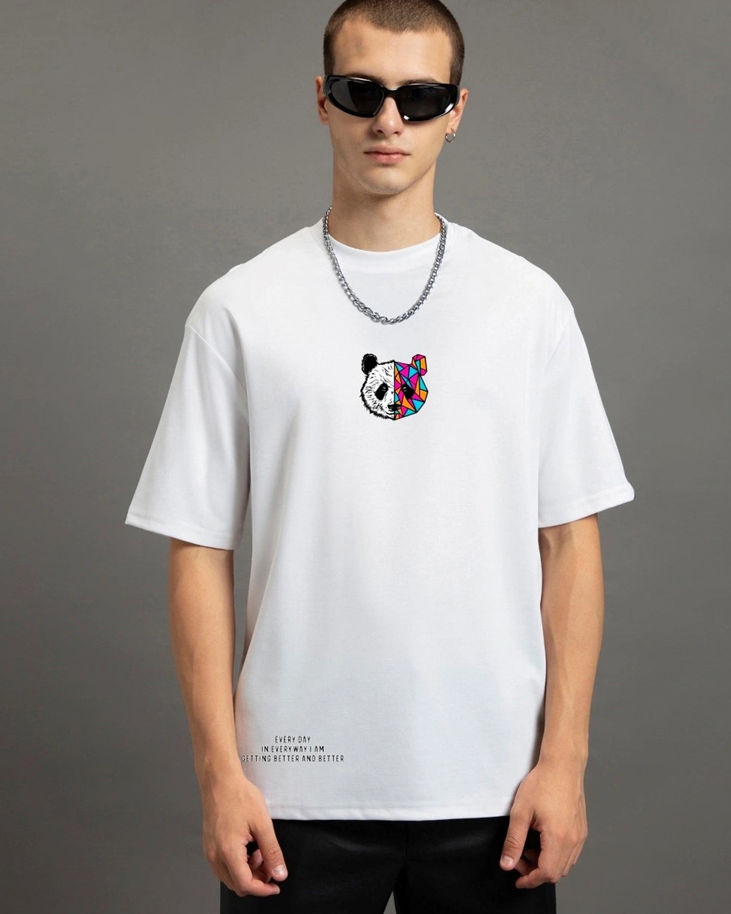 A person with dark hair and sunglasses wears a white t-shirt with a colorful panda graphic and a silver chain necklace.