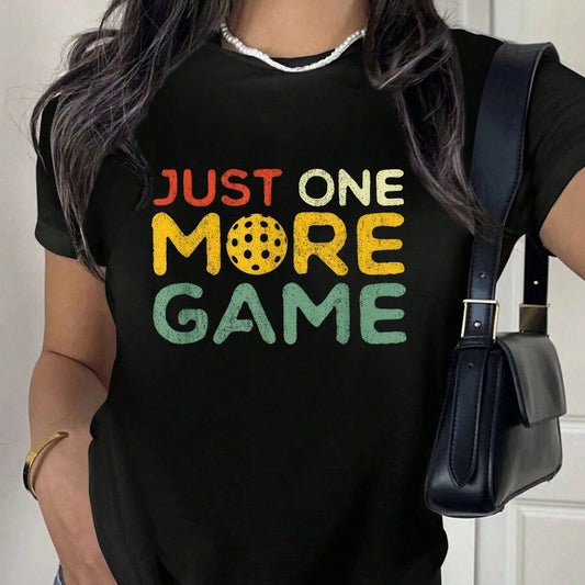 Black t-shirt with "Just one more game" text and pickleball graphic in retro colors.