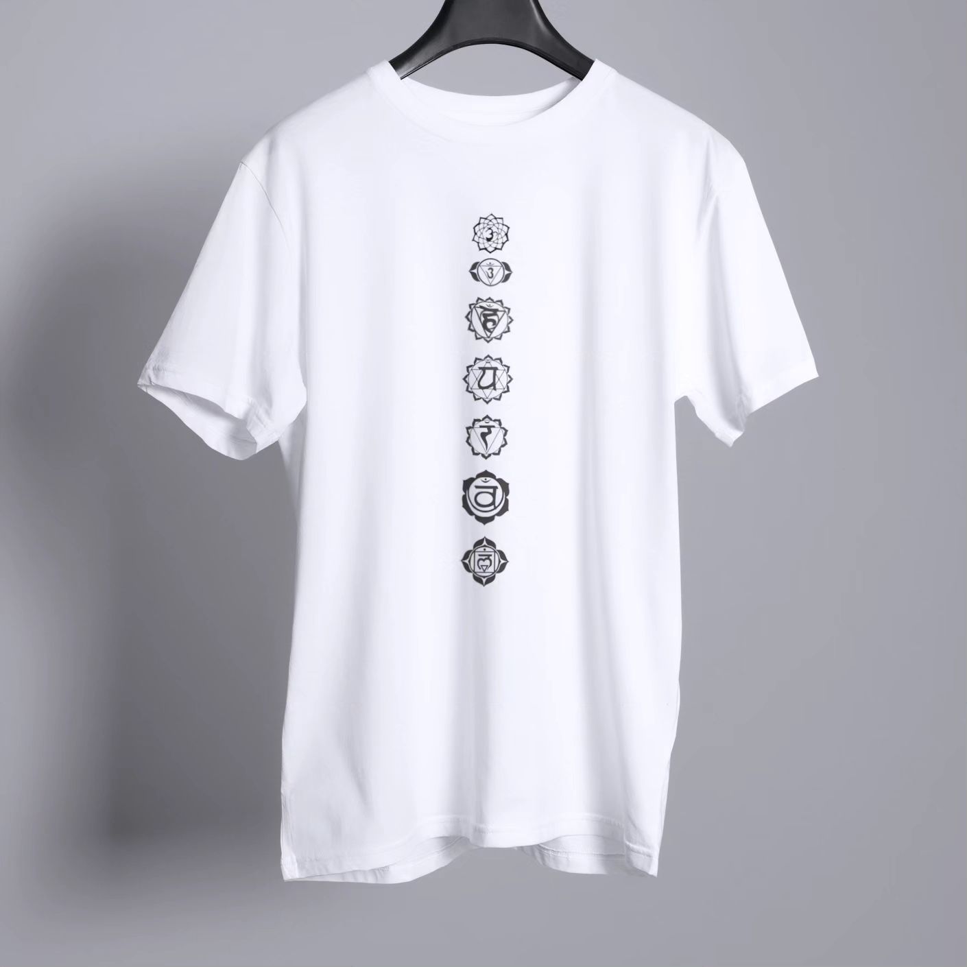 White T-Shirt with seven black chakra symbols arranged vertically, in a minimalist style, suitable for yoga or meditation.
