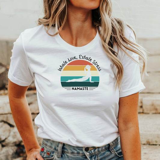 White t-shirt with "Inhale Love, Exhale Stress" quote, yoga pose, sunset graphic, and "Namaste".