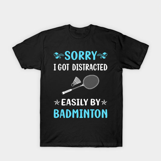 Black T-shirt with blue and white text reading 'Sorry I Got Distracted Easily by Badminton,' featuring a racket and shuttlecock graphic.