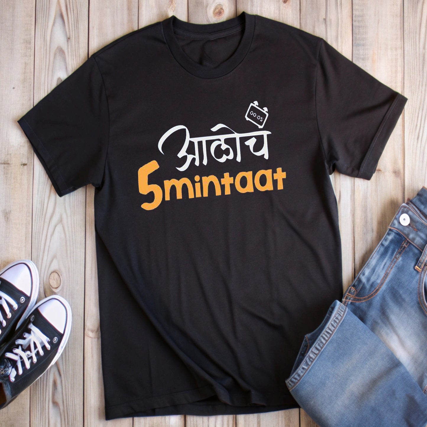 Black t-shirt with white and orange Marathi text "आलोच 5 minitaat" and a timer graphic, styled with jeans and sneakers.
