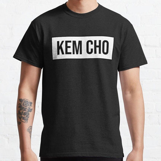 Black t-shirt with the Gujarati phrase "KEM CHO" in bold white letters inside a white rectangle. Cotton blend t-shirts, available in various sizes.