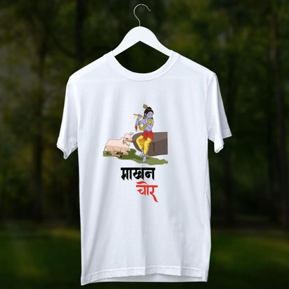White t-shirt with a colorful illustration of Krishna playing the flute beside a cow, and "माखन चोर" (Makhan Chor) written in Devanagari script below.