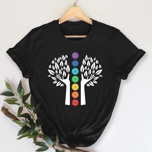 Black T-Shirt with a white graphic of a Tree of Life with seven colorful chakra symbols arranged vertically along the trunk, suitable for yoga or meditation.