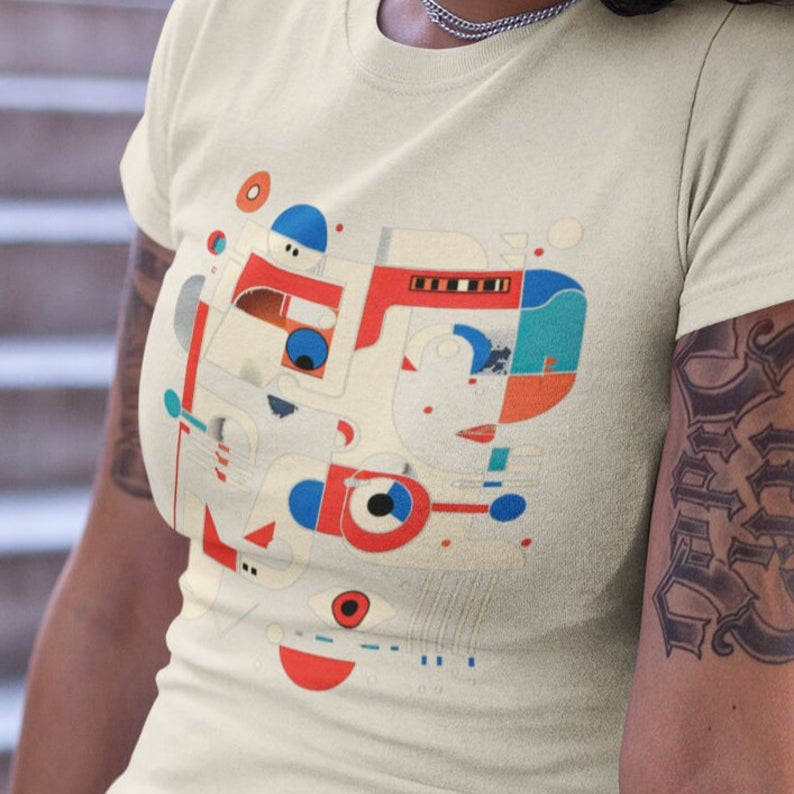 White t-shirt featuring a modern art abstract face design with geometric shapes in red, white, and blue.