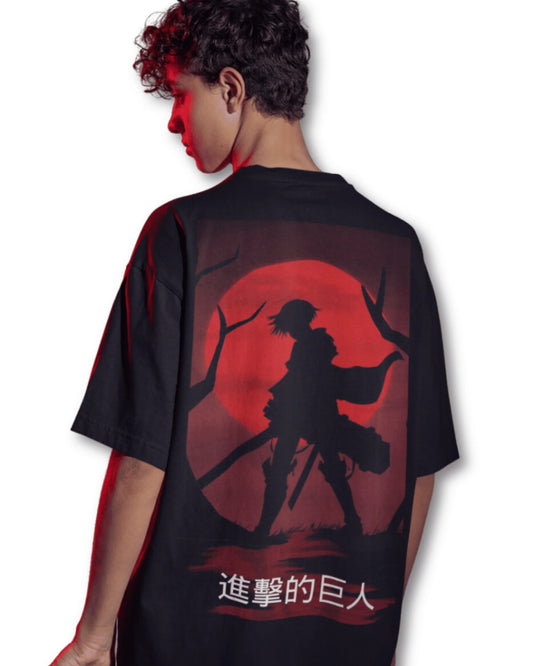 Black t-shirt with a silhouette of Eren Yeager from Attack on Titan against a red moon, worn by a young man.