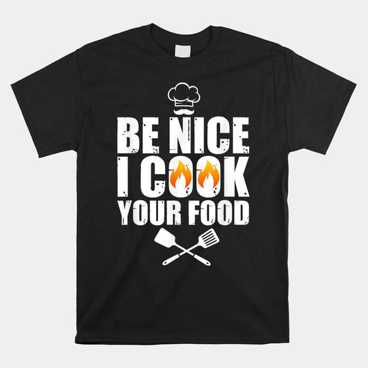 Black t-shirt with "Be Nice I Cook Your Food" text, chef hat, flames, and spatula graphics.  A humorous design for chefs and cooks.