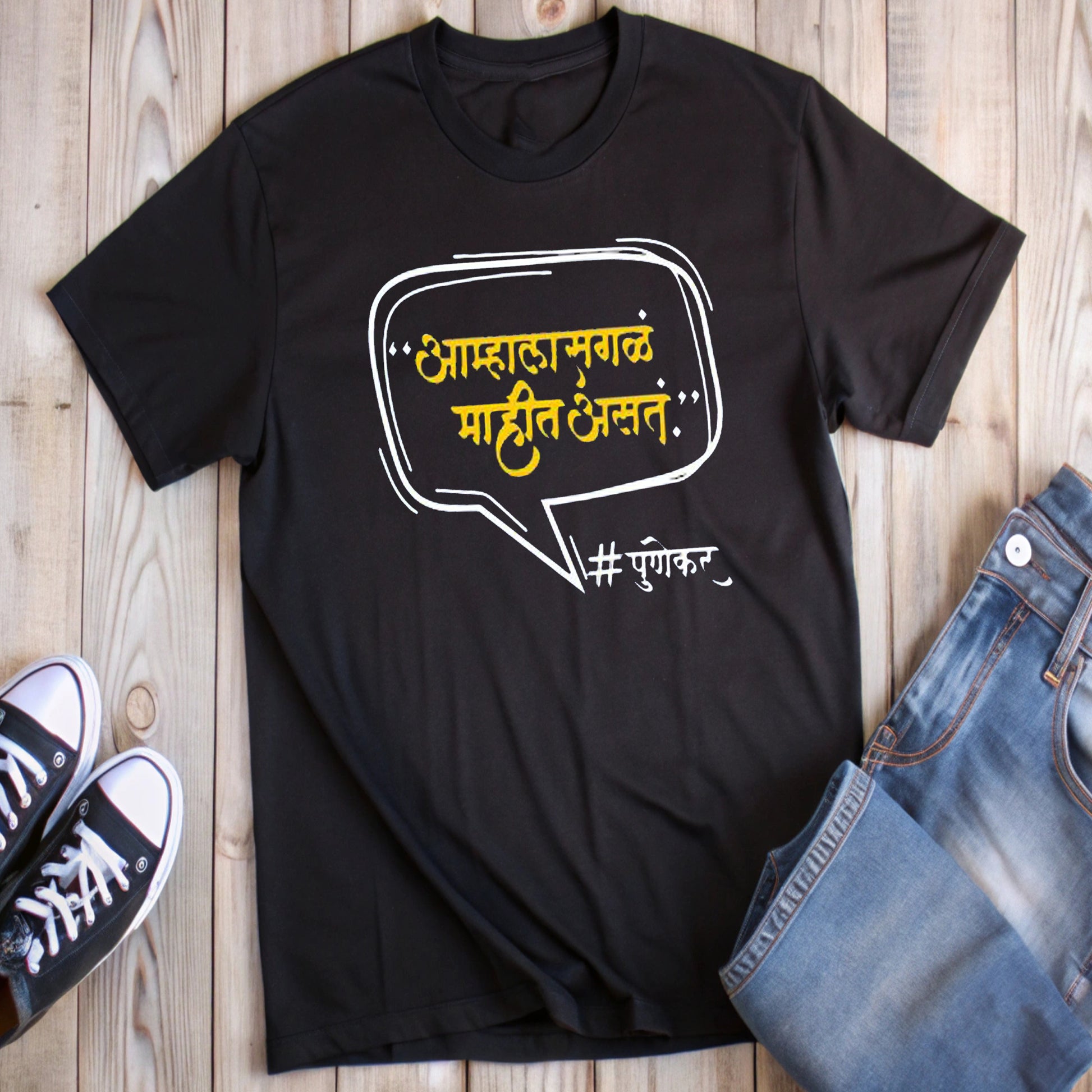  Black t-shirt with a speech bubble containing the Marathi text "आम्हाला सगळं माहीत असतं." (We know everything.) and "#पुणेकर" (Punekar), styled with jeans and sneakers.