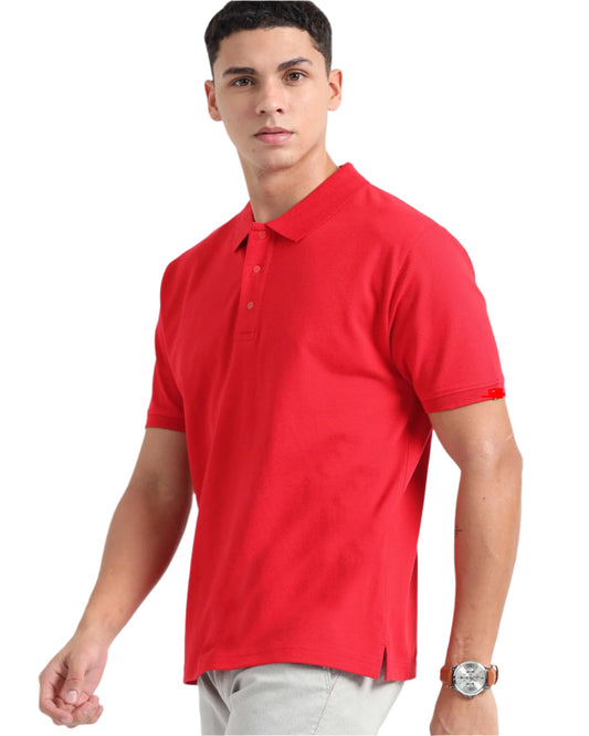 A man models a vibrant red short-sleeved polo t-shirt paired 