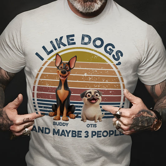 Man wearing a light-colored t-shirt with a graphic of two cartoon dogs and the phrase "I LIKE DOGS, AND MAYBE 3 PEOPLE".