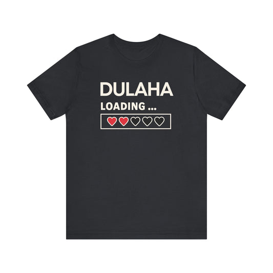 Black cotton t-shirt with white text "DULAHA" above "LOADING..." and a graphic loading bar with three filled red hearts and two empty heart outlines.