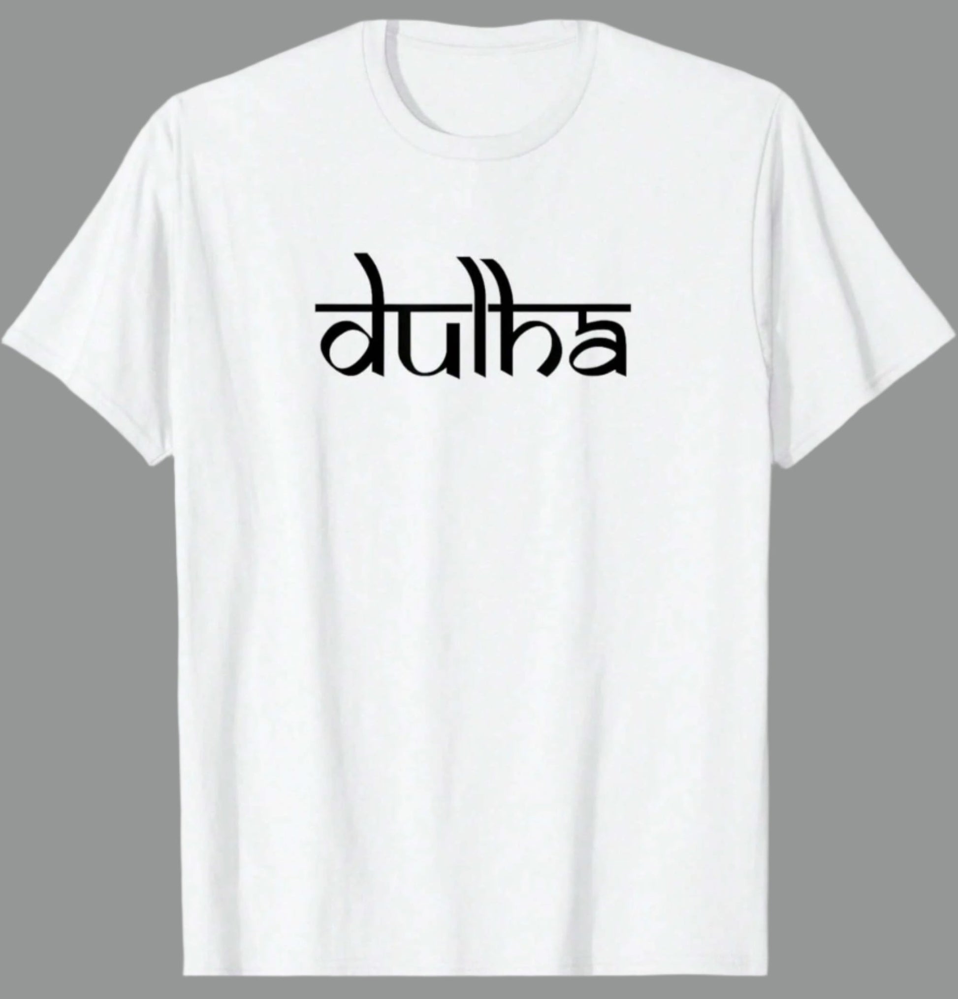 White cotton t-shirt with the word "dulha" printed in a stylized black script font. Based on the text, this likely relates to a groom in an Indian wedding context.