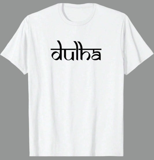 White cotton t-shirt with the word "dulha" printed in a stylized black script font. Based on the text, this likely relates to a groom in an Indian wedding context.