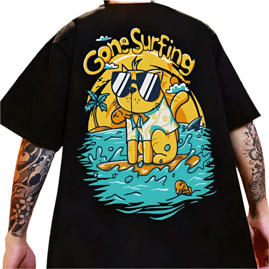 Dark-colored oversize t-shirt with a "Gone Surfing" graphic featuring a cartoon animal on a surfboard, palm trees, and ocean waves.