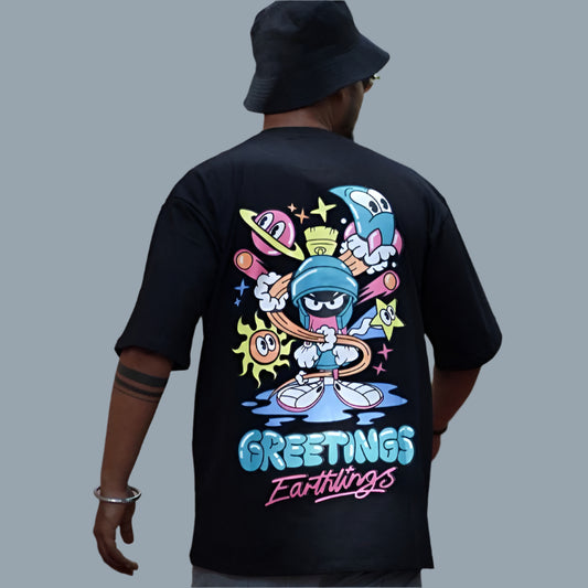 Black oversize t-shirt with a colorful cartoon character graphic and the text "GREETINGS EARTHLINGS" on the back.
