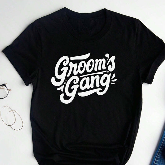 Black cotton t-shirt with white, cursive-style text reading "Groom's Gang".