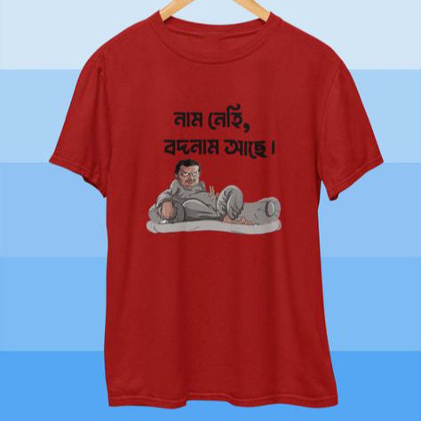 Red T-Shirt featuring a cartoon illustration of a reclining person with the Bengali text "নাম নেই, বদনাম আছে!" implying a lack of positive reputation.