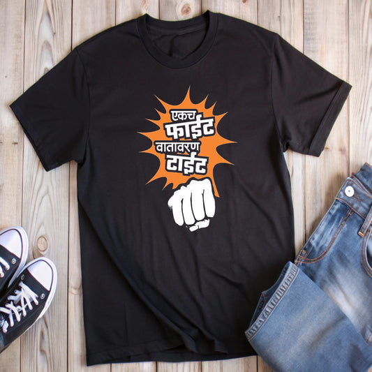 Black t-shirt with orange and white text "एकच फाईट वातावरण टाईट" (One fight, the atmosphere is tense) above a white cartoon fist. The text is in Marathi, suggesting a possible cultural context related to Maharashtra, India.