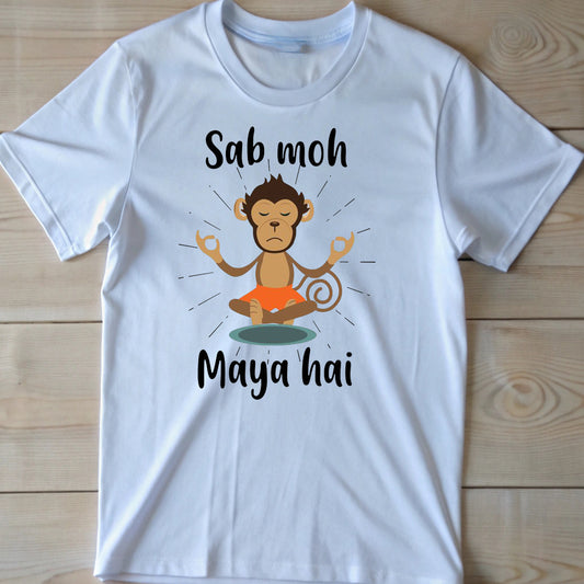 White t-shirt with black text "Sab moh" above a meditating cartoon monkey and "Maya hai" below it. The Hindi phrase "Sab moh maya hai" translates to "All worldly attachments are illusions".