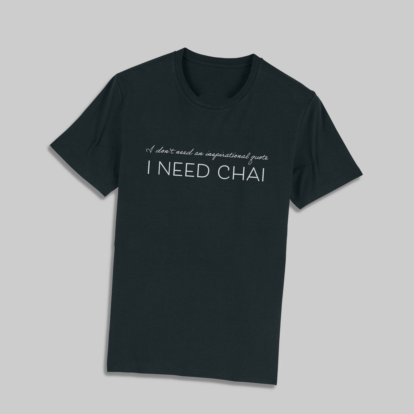 Dark t-shirt with "I don't need an inspirational quote, I NEED CHAI" text in white. A humorous and relatable design for chai lovers.