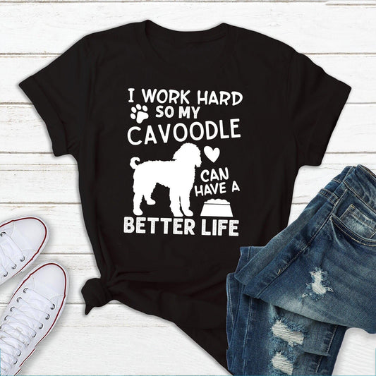 Black t-shirt with white text and a Cavoodle silhouette, flat lay with shoes and jeans