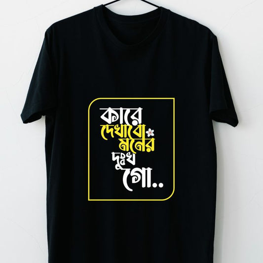 Black t-shirt with Bengali script "Kare Dekhabi Moner Dukkho" in yellow and white inside a yellow square.