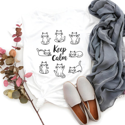 White T-Shirt featuring the text "Keep Calm" surrounded by various illustrations of cute cats in different poses.