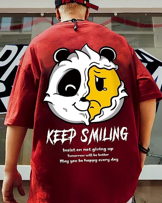  Red T-shirt featuring a playful dual-faced panda design—one side smiling, the other frowning—centered on the chest. The phrase "Keep Smiling" arches above the panda in bold white lettering.


