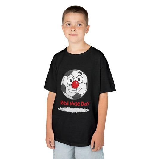 A young boy wears a black t-shirt with a cartoon soccer ball wearing a red nose and the text "Red Nose Day".