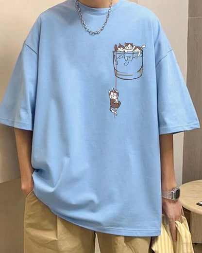 Light blue t-shirt with a graphic of kittens in a pocket, worn by a person with a silver necklace.