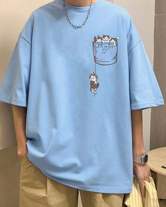 Light blue t-shirt with a graphic of kittens in a pocket, worn by a person with a silver necklace.