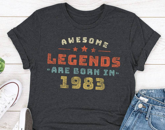 Dark grey t-shirt with "Awesome Legends Are Born In 1983" in a retro, distressed font.  Classic fit, perfect for a 40th birthday gift.