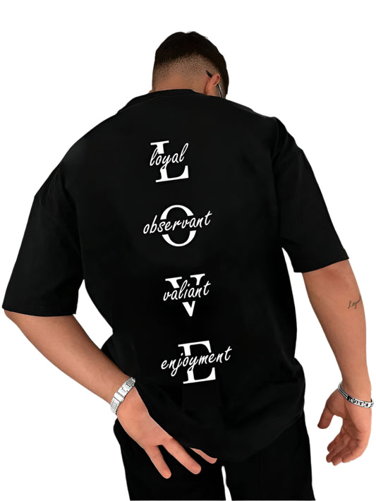 Black oversize t-shirt with "loyal," "observant," "valiant," and "enjoyment" stacked vertically on the back, emphasizing the letters to spell "LOVE." The model is wearing the shirt, showing the back view.