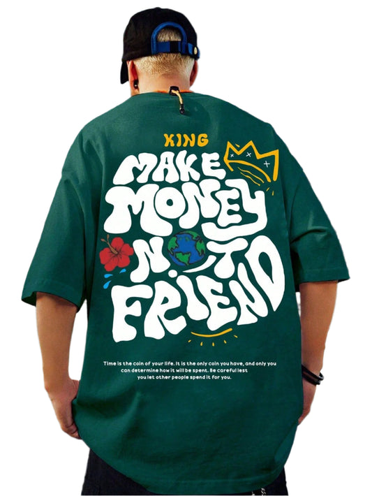 Green oversize t-shirt with "Make Money Not Friends" text in a stylized font, a crown graphic, a globe graphic, and a floral graphic on the back. A quote about time and life is printed at the bottom. The model is wearing the shirt and facing away from the camera, showing the back graphic.
