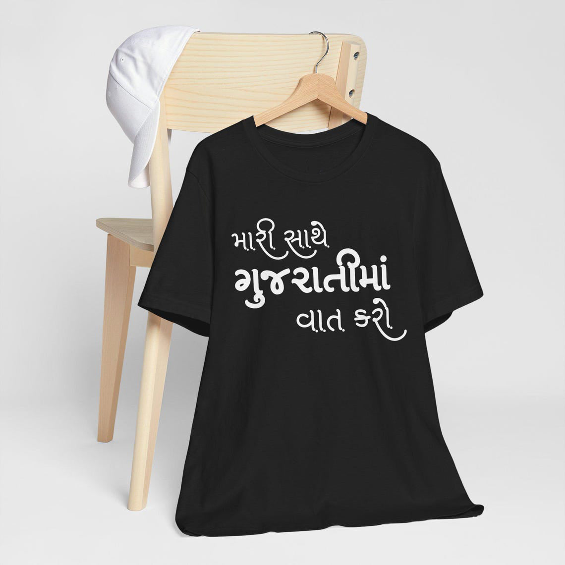 Black t-shirt with the Gujarati phrase "મારી સાથે ગુજરાતીમાં વાત કરો" (mārī sāthe gujarātīmā̃ vāt karo - talk to me in Gujarati) in white text. Cotton blend t-shirts, available in various sizes.