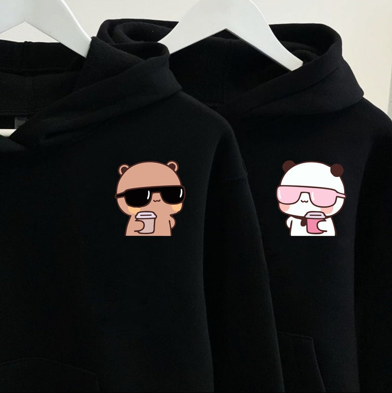 Two black hoodies with a bear wearing sunglasses and a panda with a drink design.
