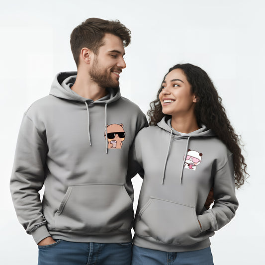 A smiling man and woman wearing matching gray hoodies with bear and panda designs.