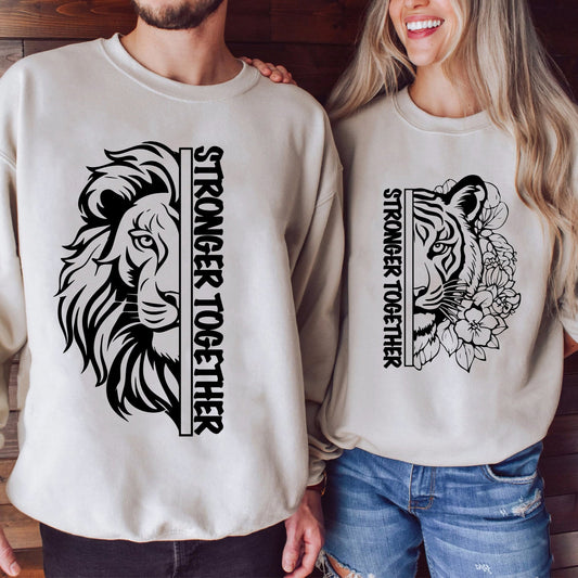 A couple wears matching light beige sweatshirts with a split lion and tiger face graphic and the text "STRONGER TOGETHER".