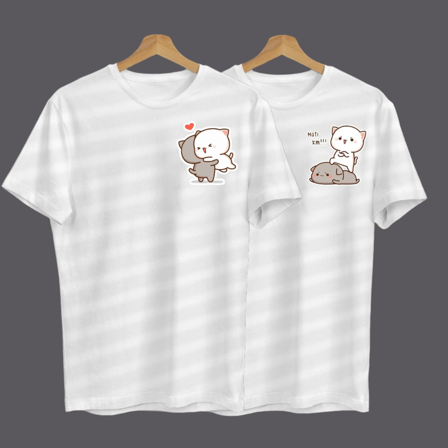 Two white t-shirts on hangers feature adorable cartoon cats in different loving poses.