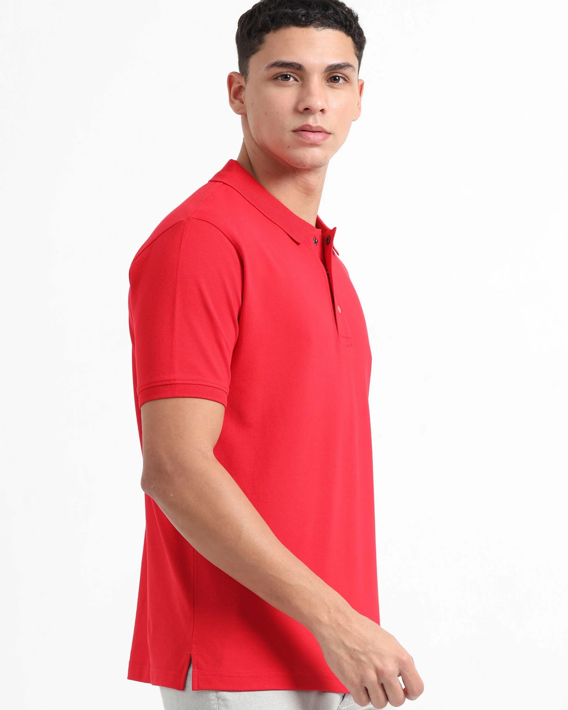 A men is shown in a side view, wearing a bright red polo t-shirt.