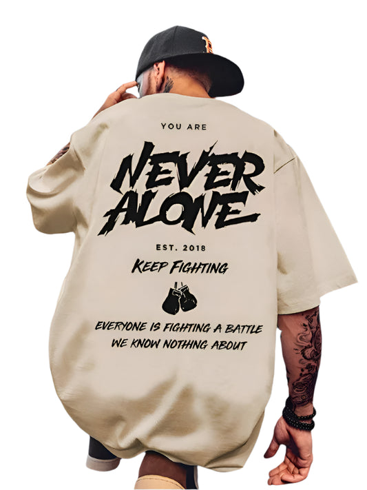 Light-colored oversize t-shirt with "You Are Never Alone", "Keep Fighting", boxing glove graphics, and "Everyone is Fighting a Battle We Know Nothing About" text on the back.