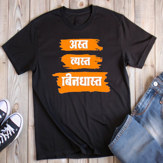 Black t-shirt with distressed orange and white Marathi text "अस्त व्यस्त बिनधास्त" (Existing, Busy, Carefree), styled with jeans and sneakers.