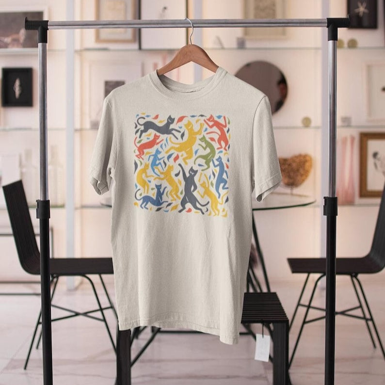 Off-White t-shirt on a hanger features a colorful pattern of dancing cats reminiscent of Matisse's "The Dance."