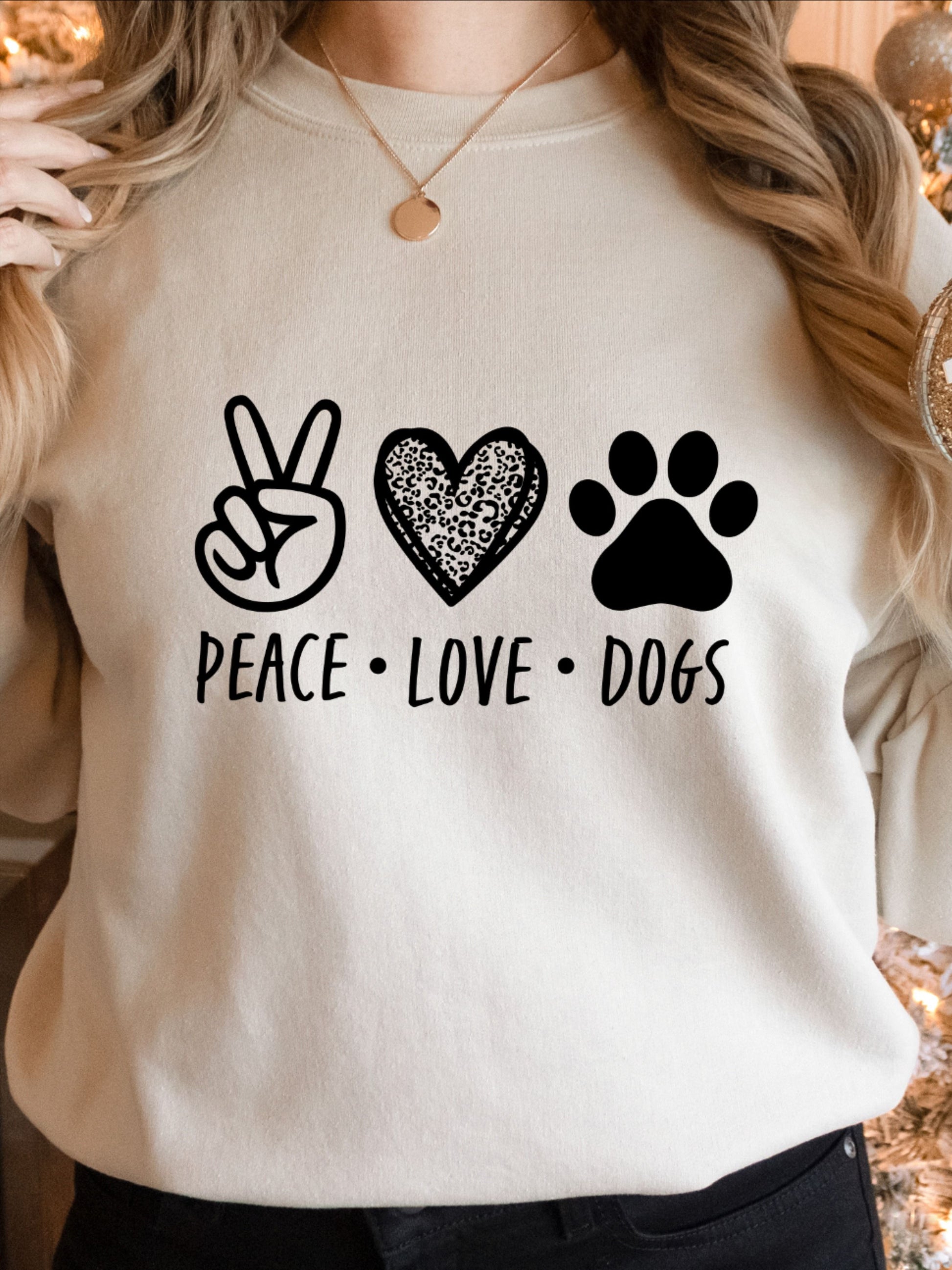  A light-colored t-shirt with "Peace Love Dogs" graphic featuring a peace sign, heart, and paw print.