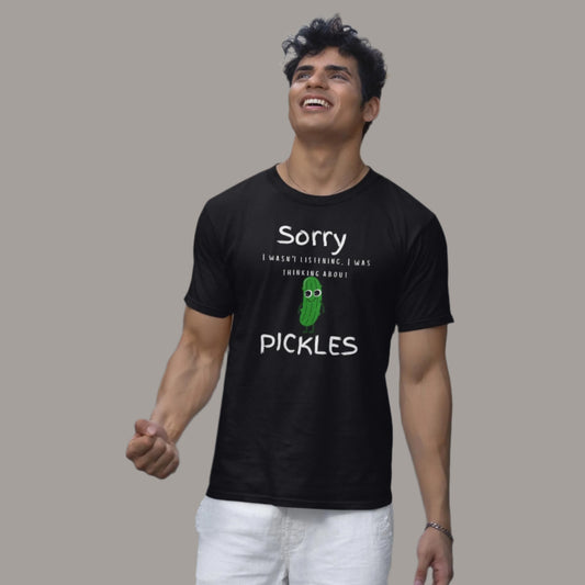 Black t-shirt with "Sorry I wasn't listening, I was thinking about pickles" text and a pickle graphic. A fun, relatable design for pickle lovers.
