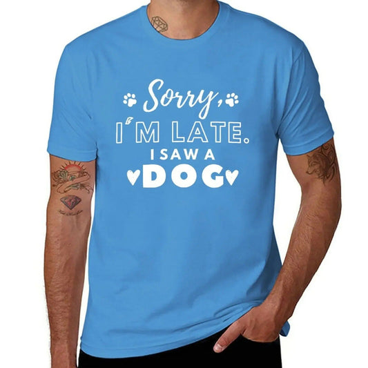 Light blue t-shirt with white text saying "Sorry, I'm Late. I Saw A Dog." and paw print accents.
